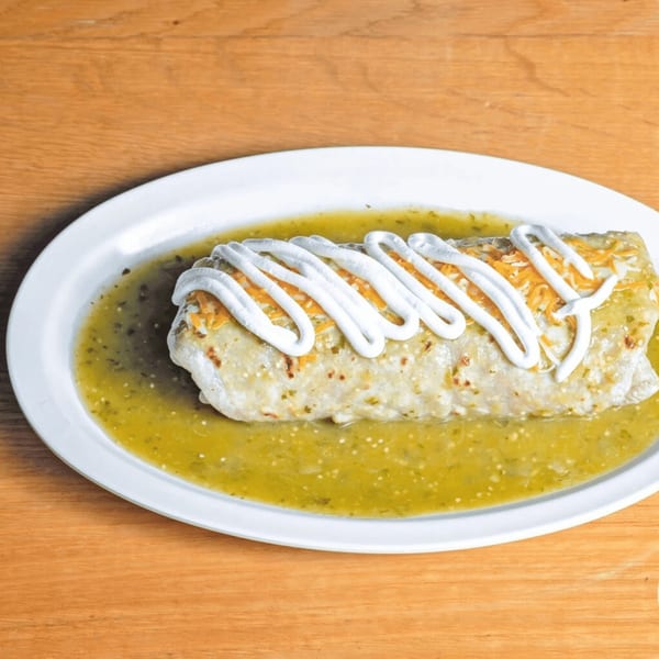 Las Salsas Taqueria's burrito smothered in green salsa, topped with sour cream and shredded cheese.