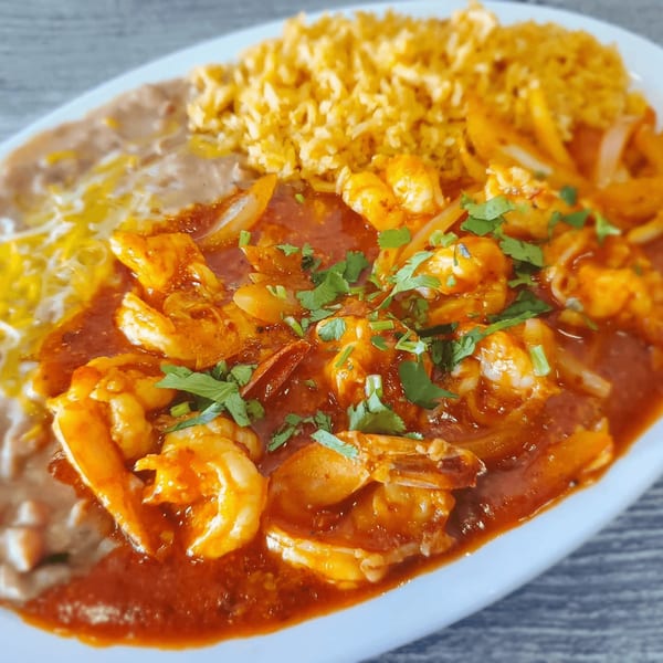 Las Salsas Taqueria's Camarones a la Diabla with rice and refried beans on a white plate.